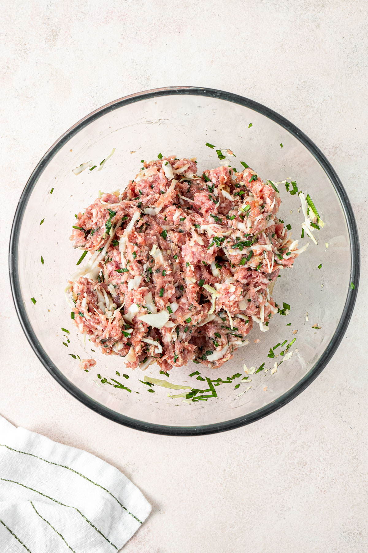 The pork and chive dumpling mixture on a glass bowl.