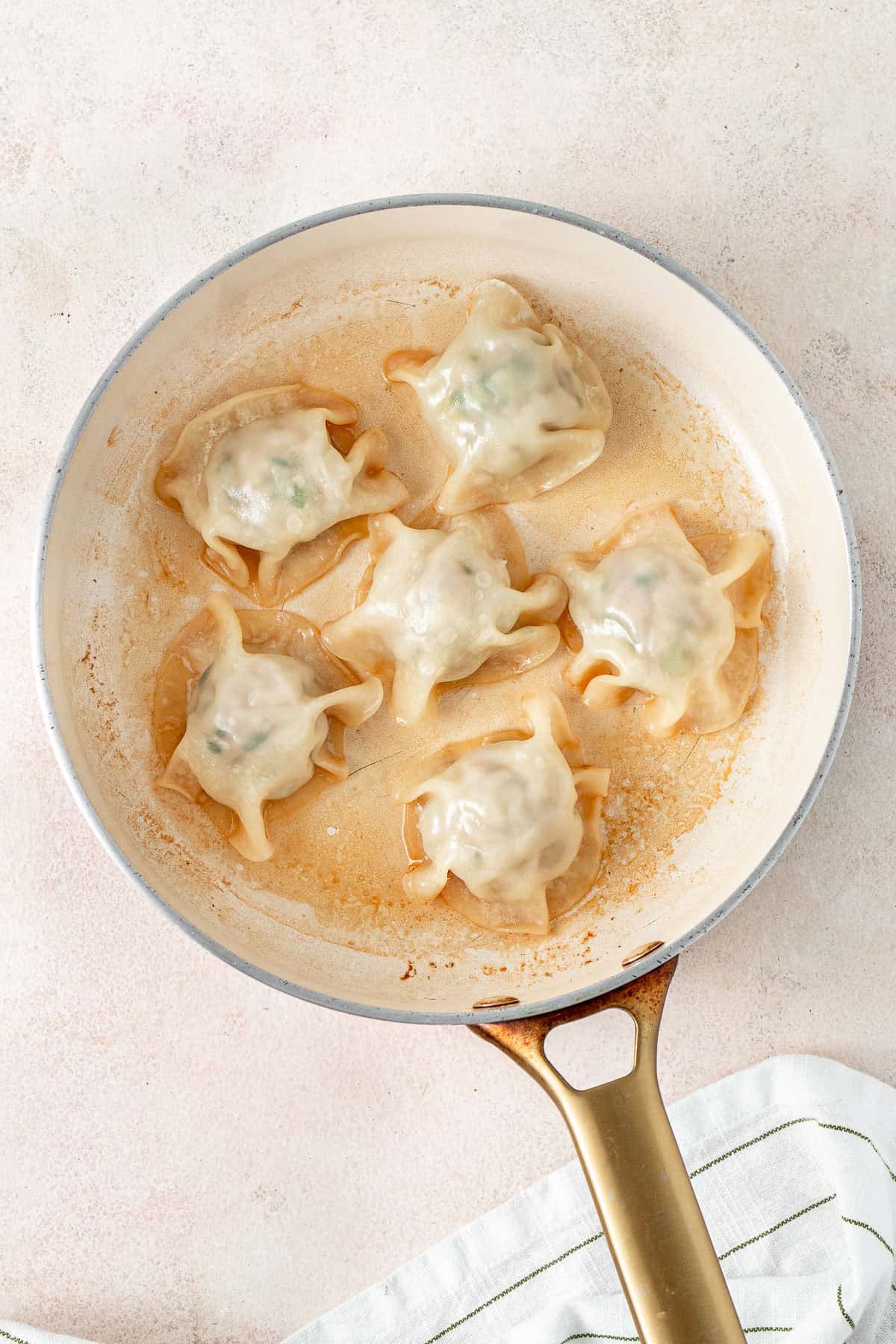 The cooked dumplings in the frying pan.