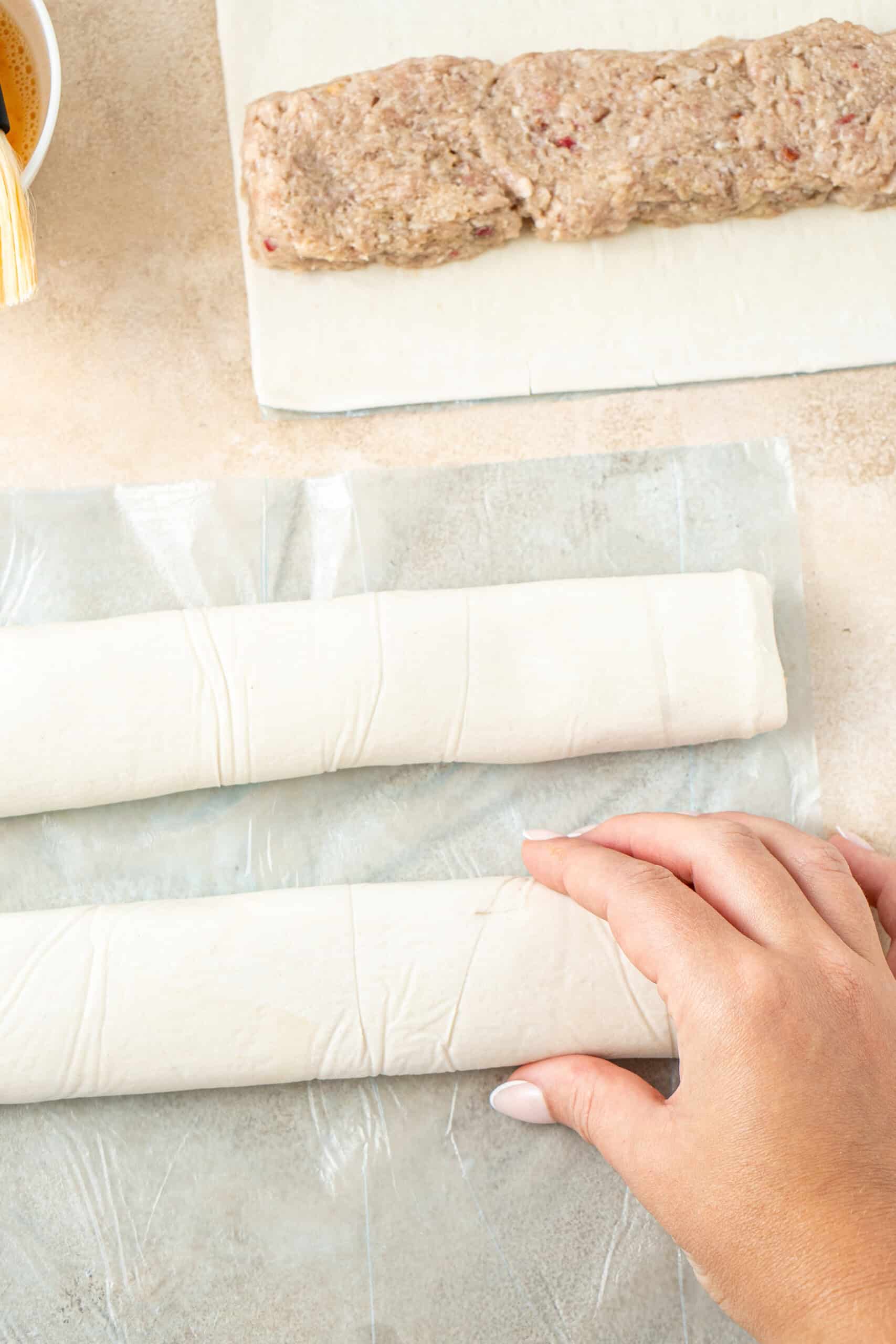 Shaping the sausage rolls into logs.