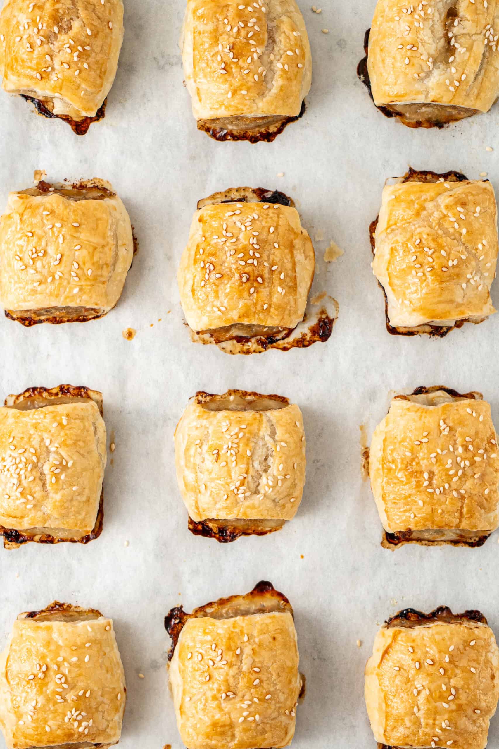 The baked sausage rolls on a baking tray.