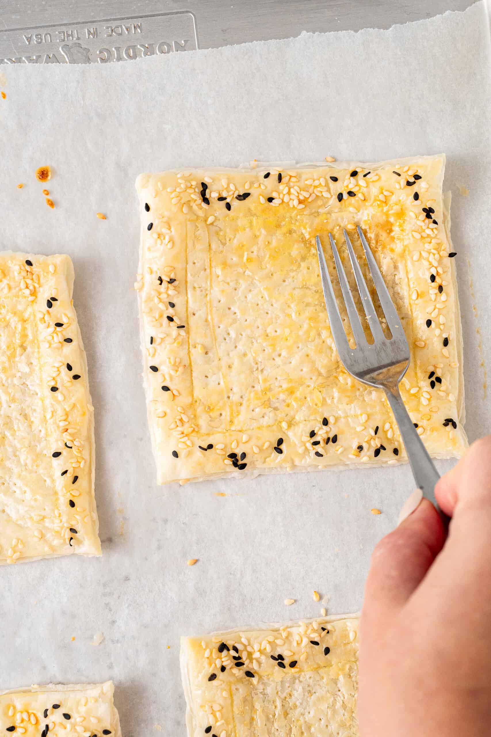 Pushing down the pastry tart with a fork.