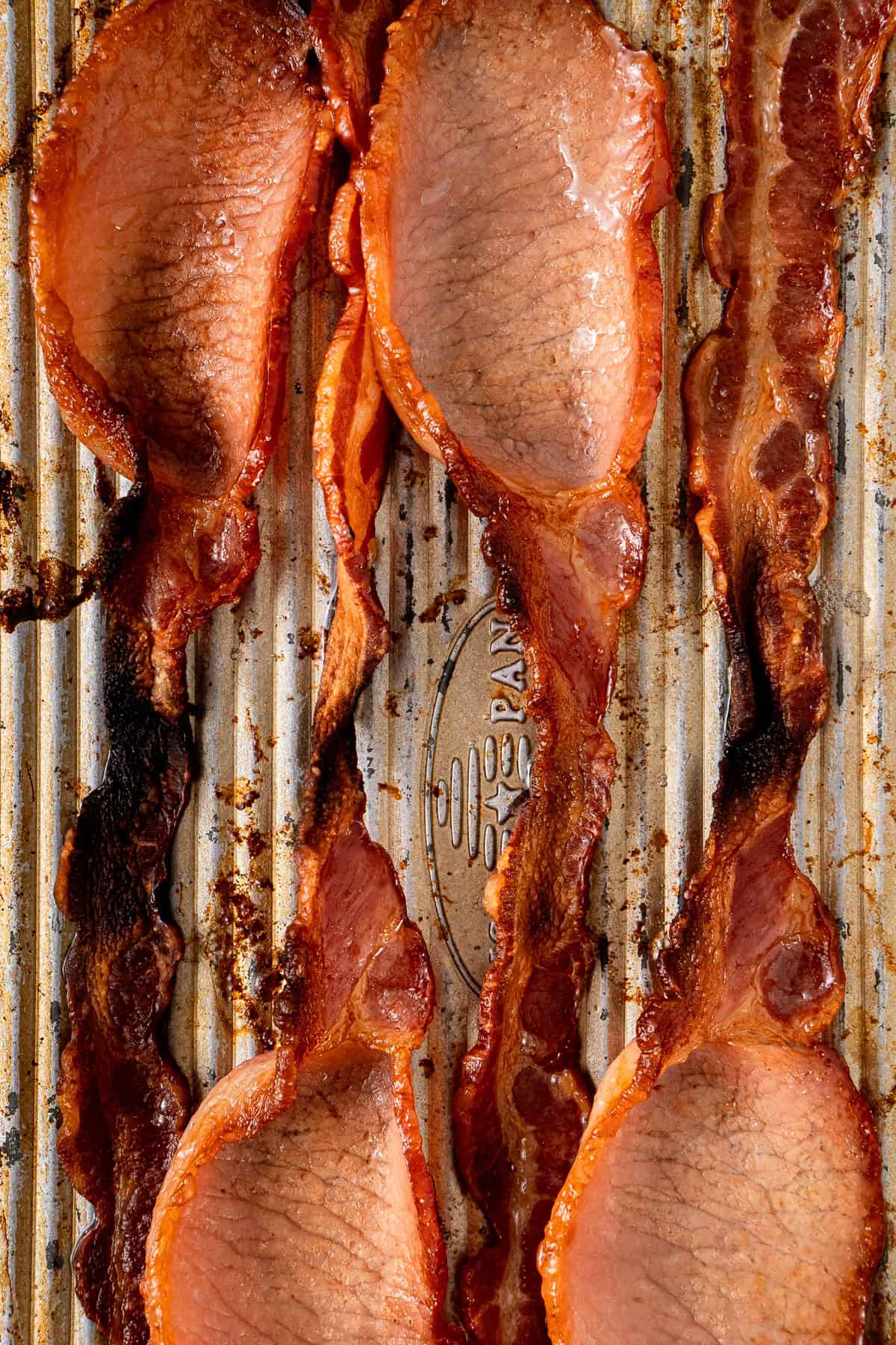 Crispy cooked bacon on a baking tray.