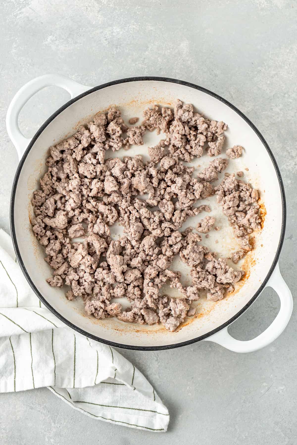 Browning the pork in a frying pan.