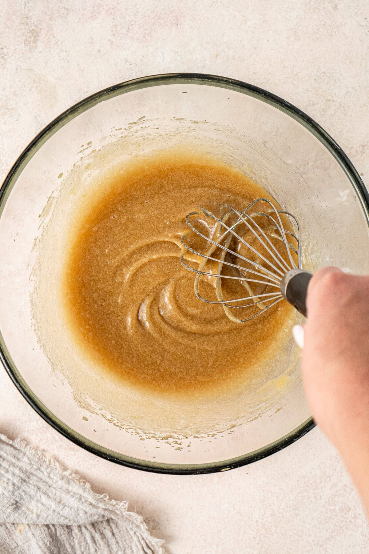 Whisking together the wet ingredients in a glass bowl.