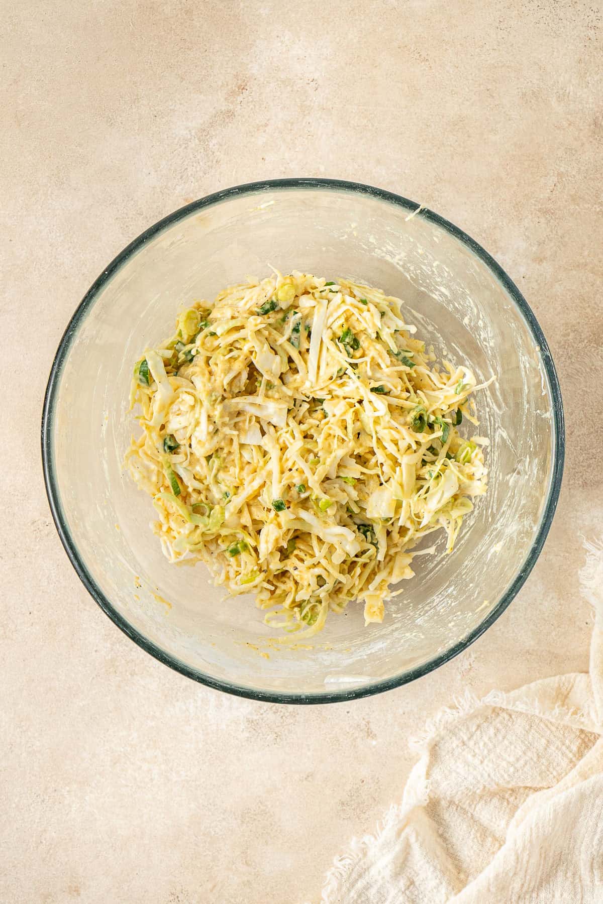 The cabbage fritter batter in a glass mixing bowl.