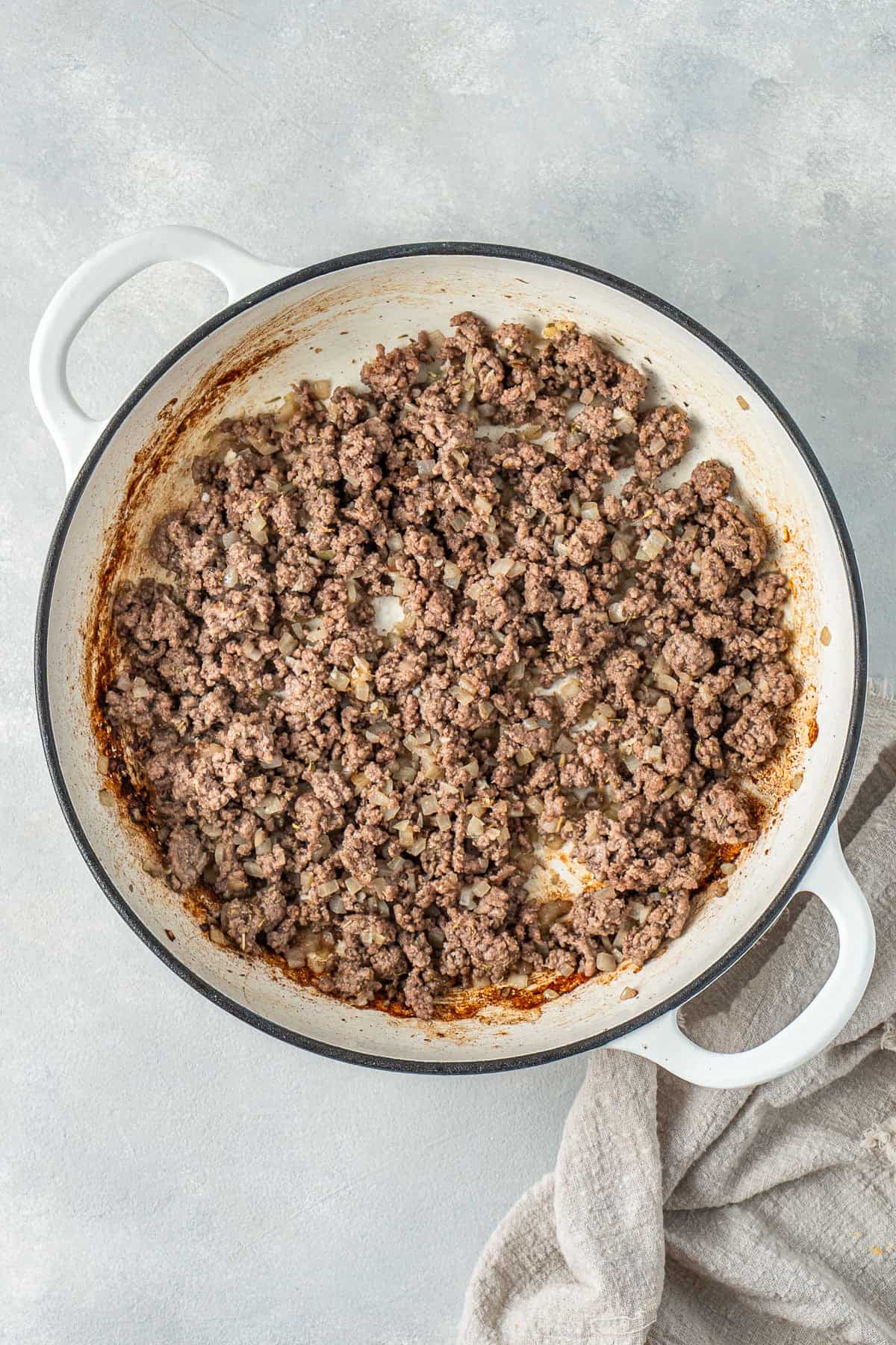 The browned beef in a pan.
