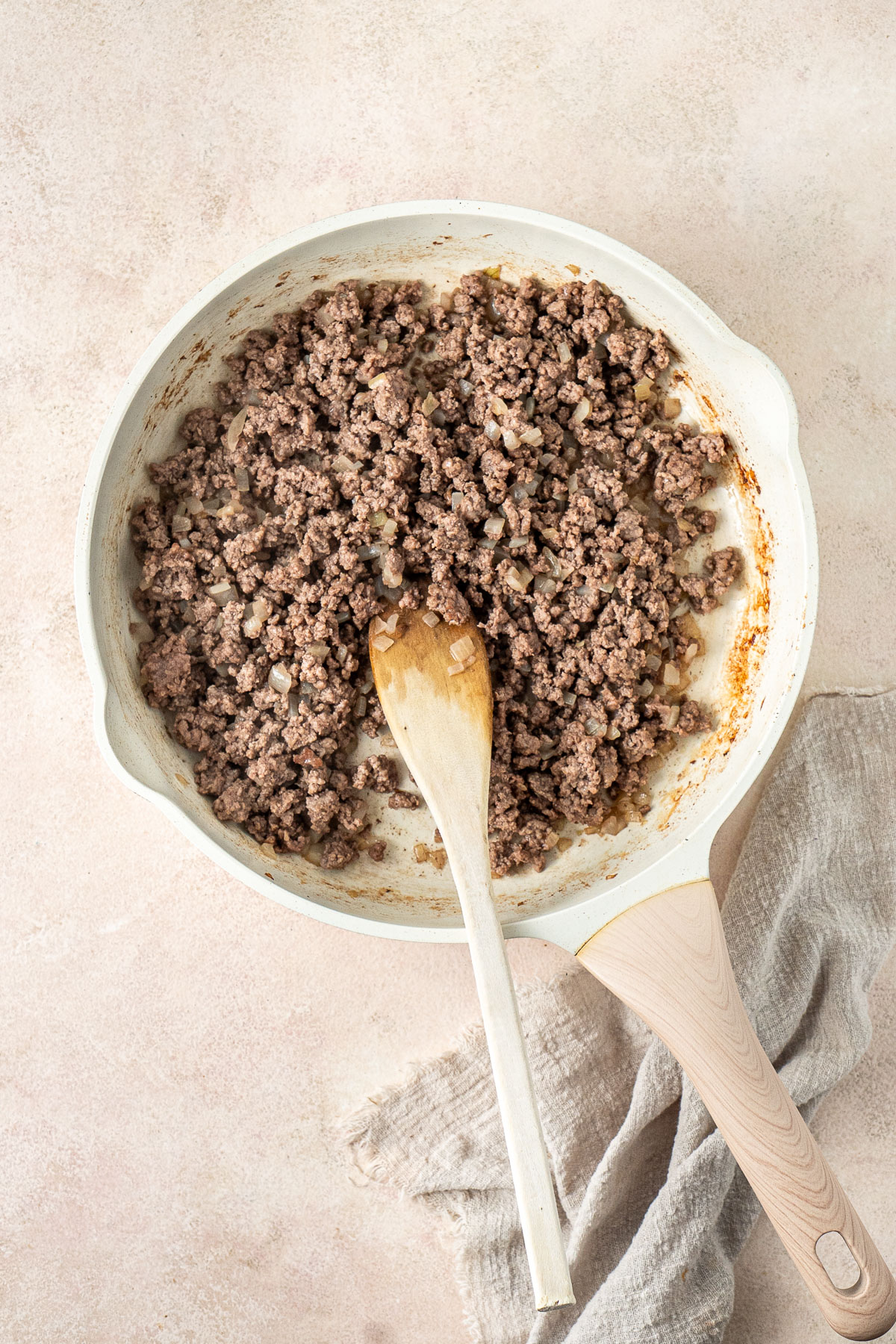 Browning the beef and onions in a frying pan.