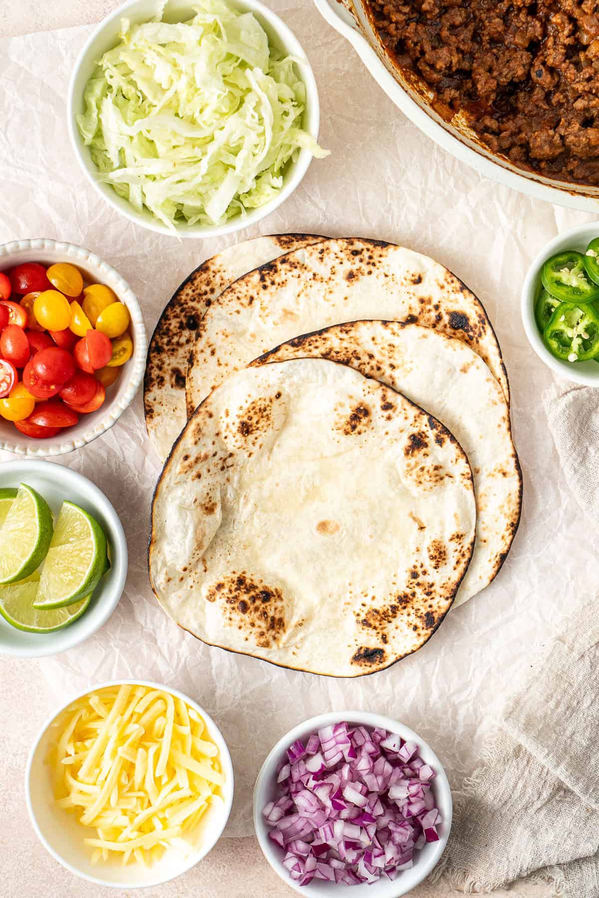 The charred flour tortillas laid out with all the toppings. 