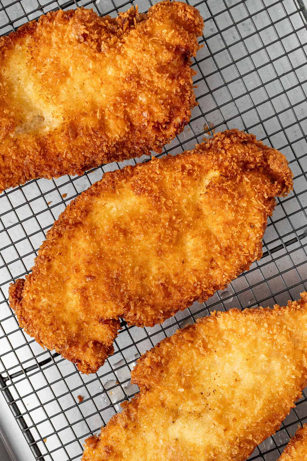 Chicken schnitzels cooked on a wire rack.
