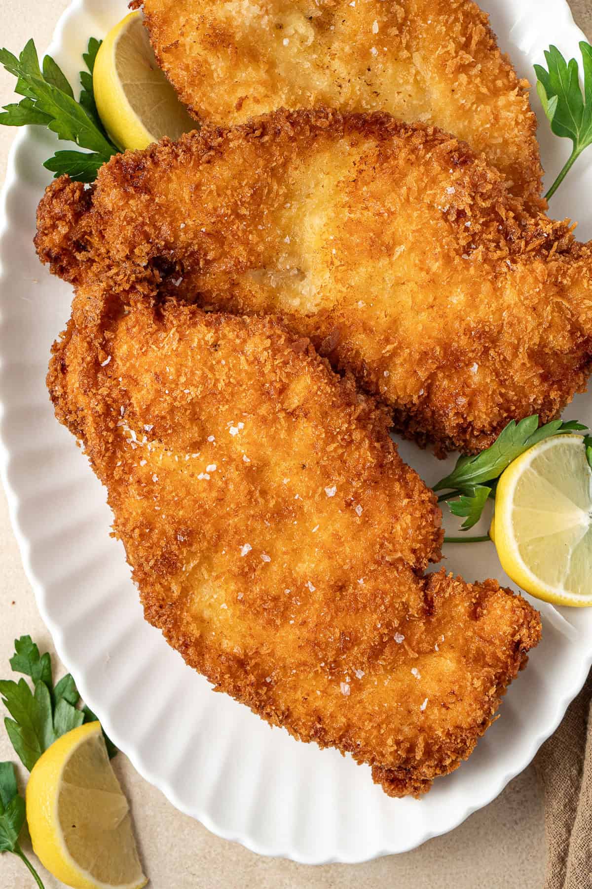 Chicken schnitzels on a white plate.