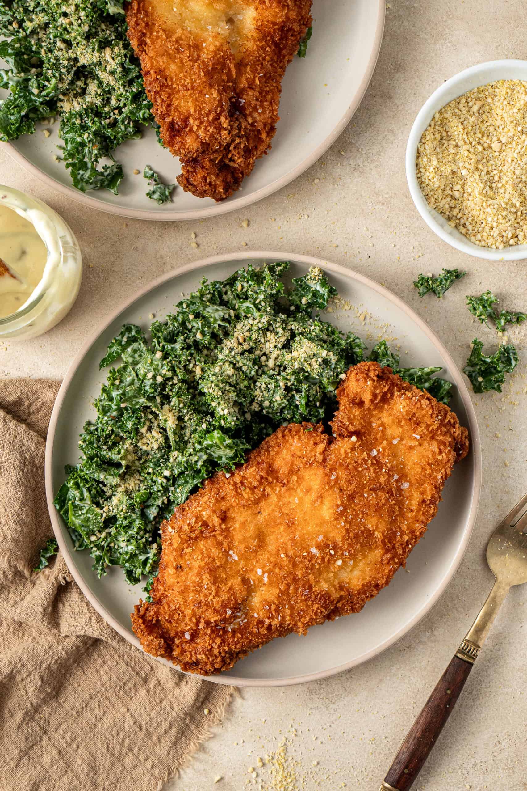 The kale salad served on a plate with the chicken.