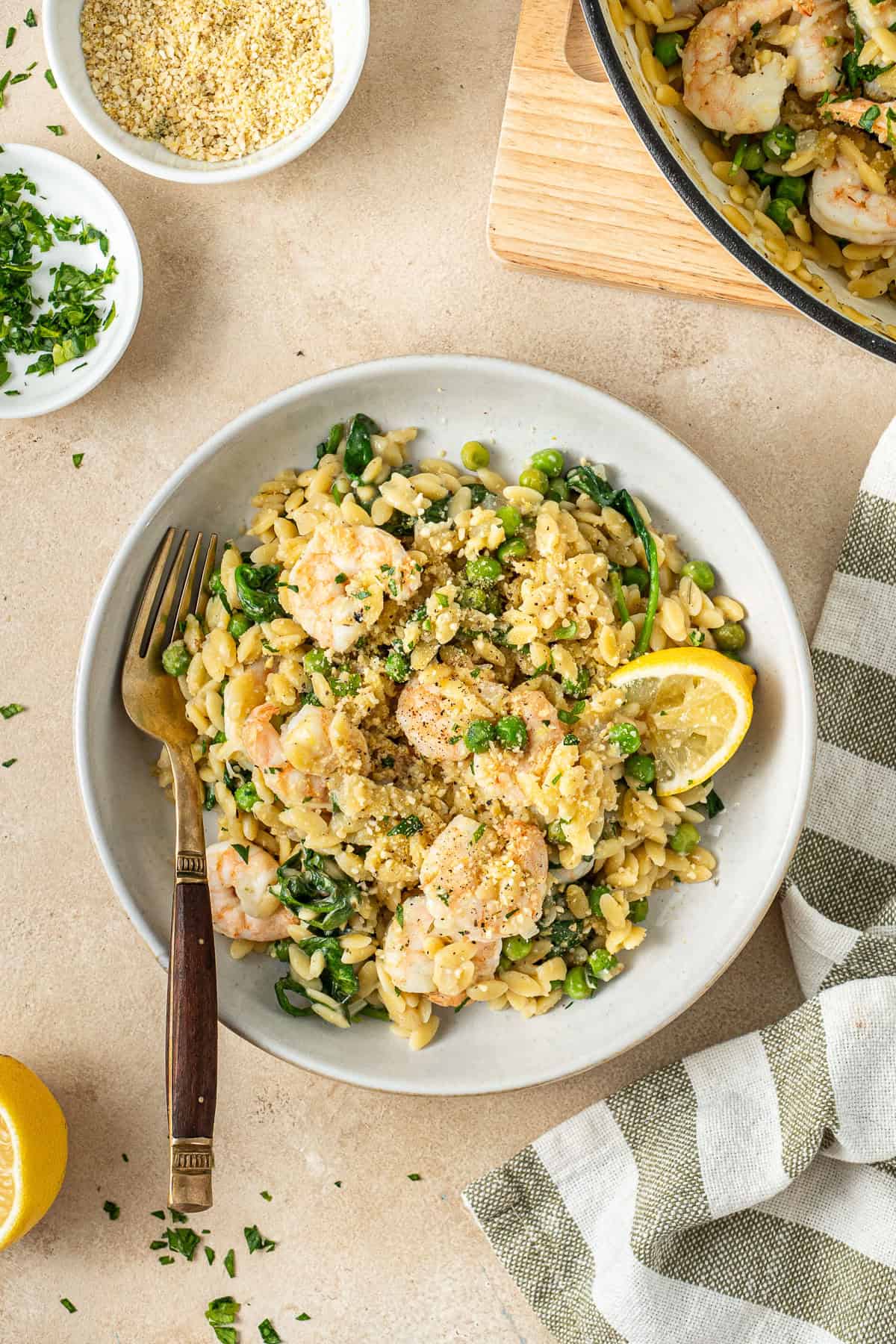 Lemon orzo with prawns served in a bowl with a fork.