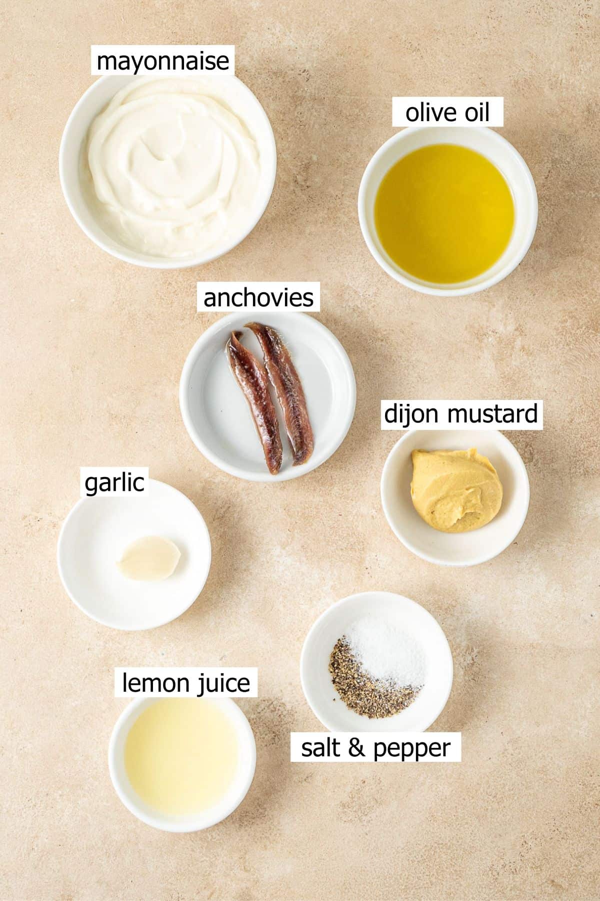 All ingredients needed to make dairy free caesar salad dressing laid out in small bowls.