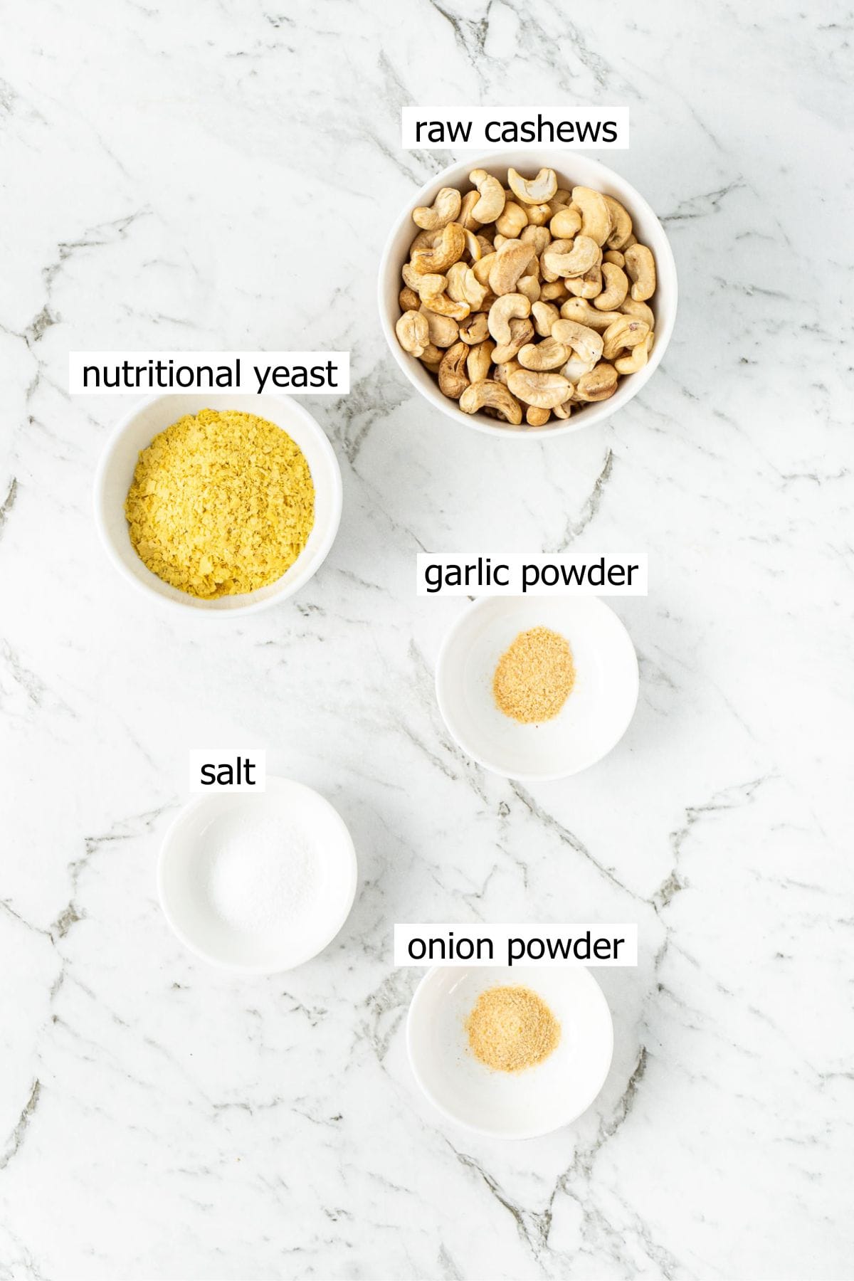 All ingredients needed to make dairy free parmesan laid out in small bowls.