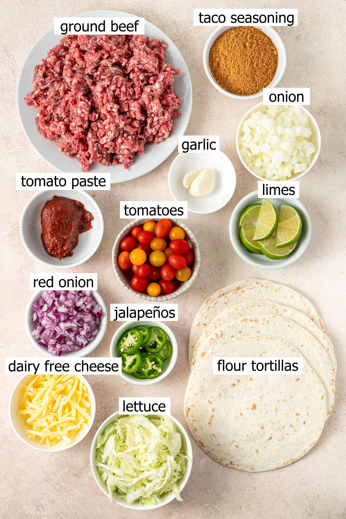 All ingredients needed to make ground beef tacos laid out in bowls.