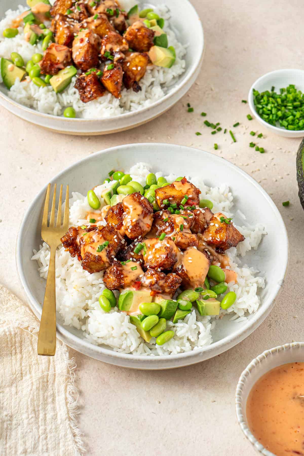 The bang bang tofu served in rice bowls with extra sauce.