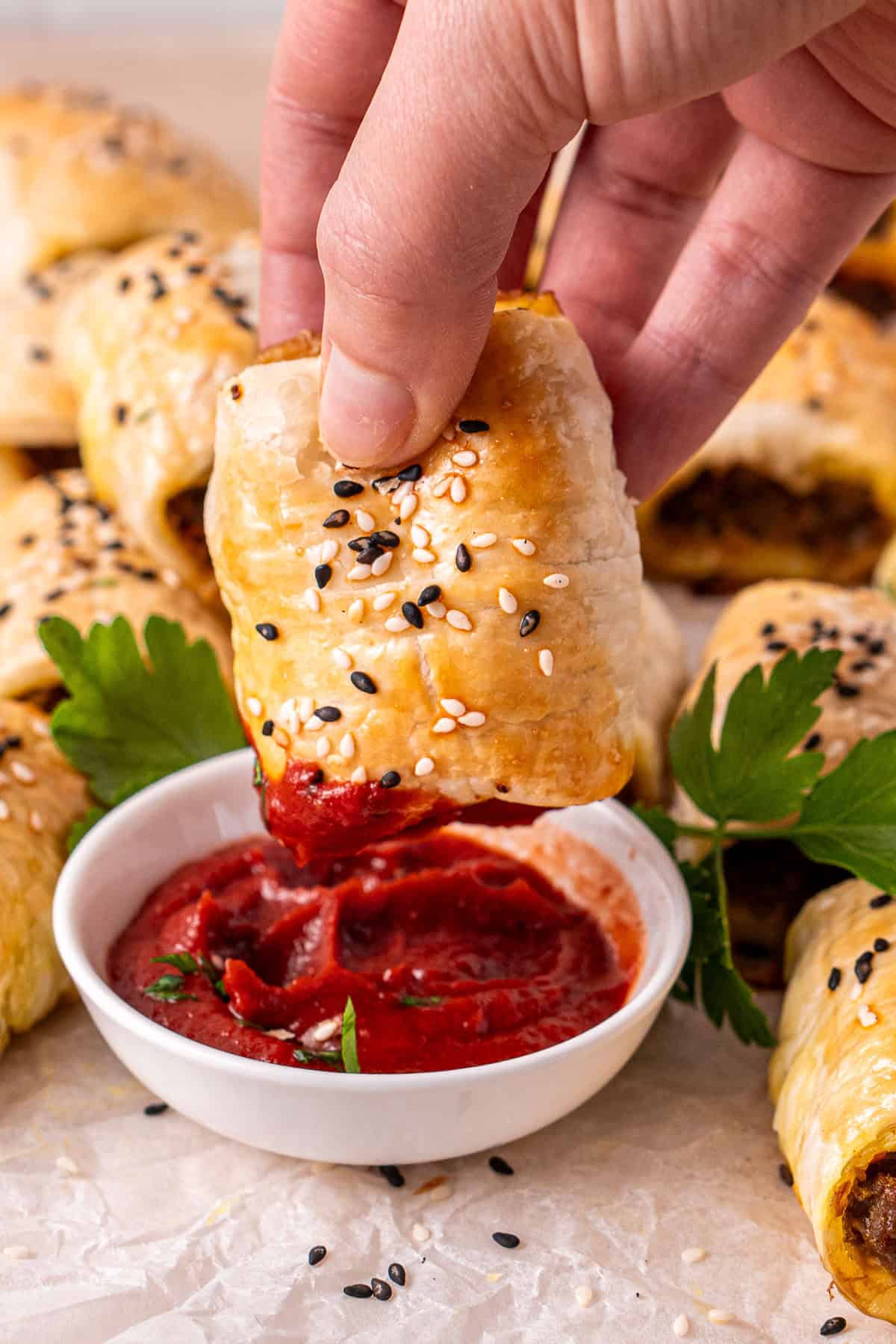 Dipping the curry sausage roll into tomato sauce.