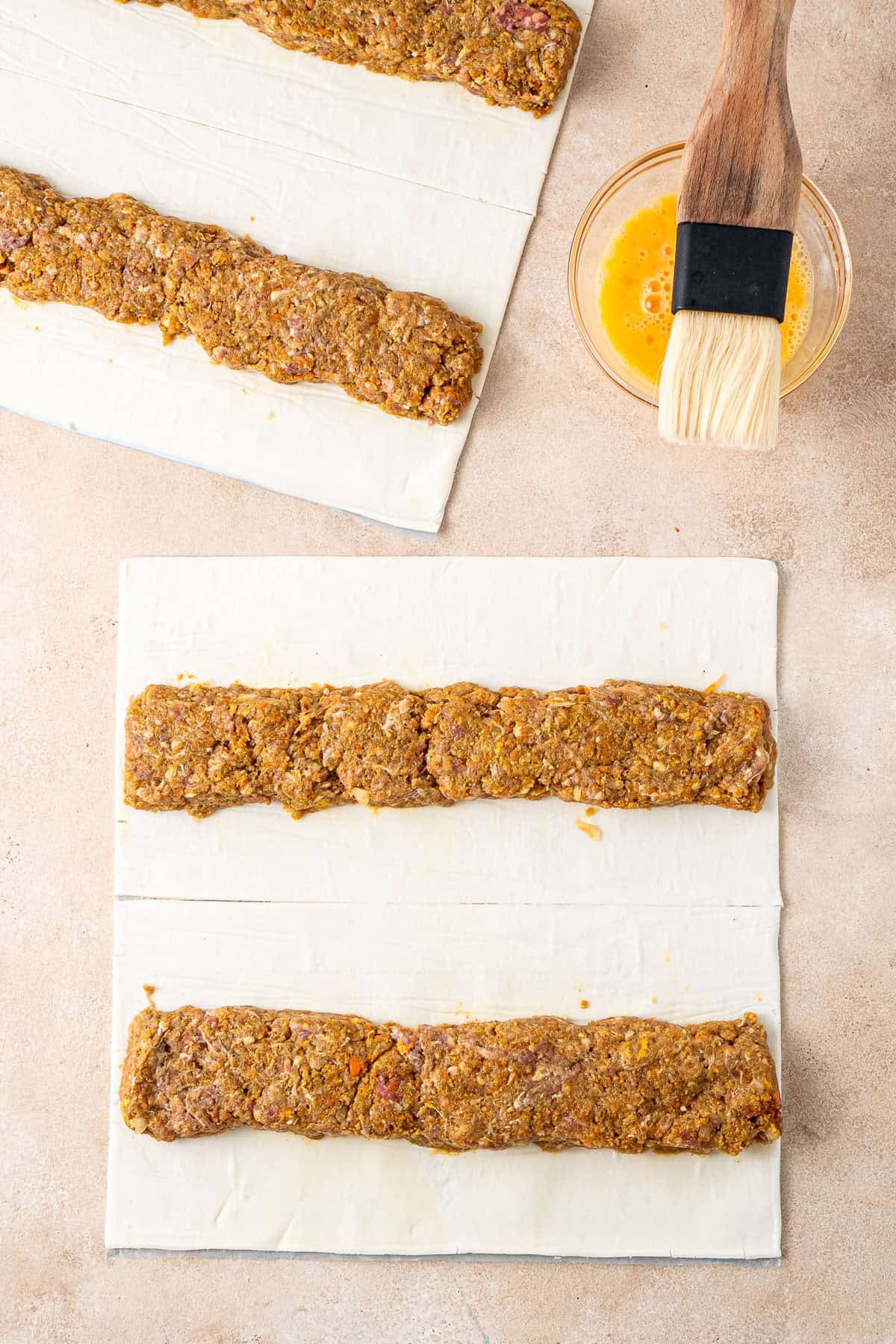 The pastry laid out with log of beef filling.