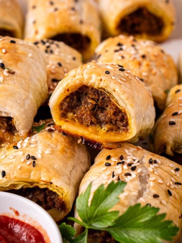 Curried beef sausage rolls with tomato sauce.