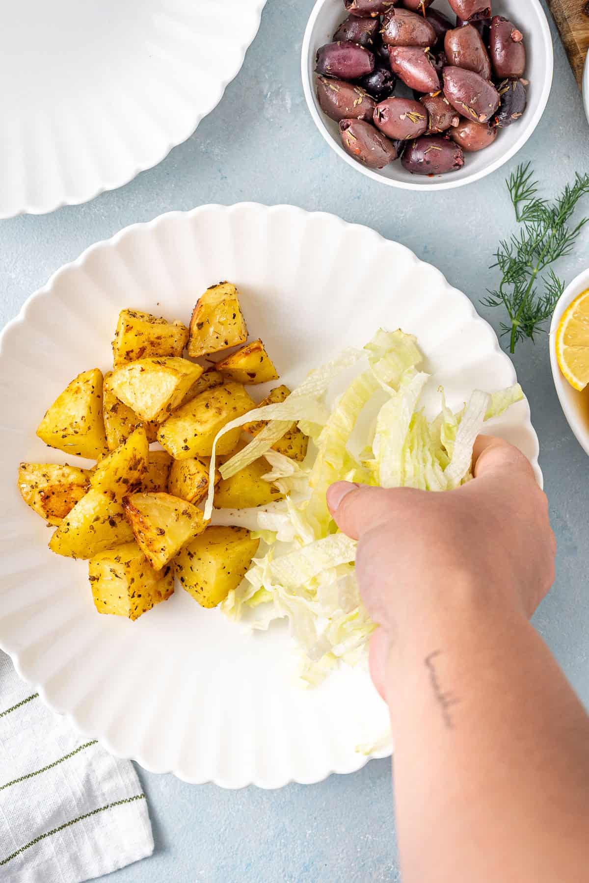 Assembling the bowls with lettuce and roasted potatoes.