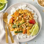 The served satay chicken over rice with fresh lime.
