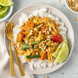 The served satay chicken over rice with fresh lime.