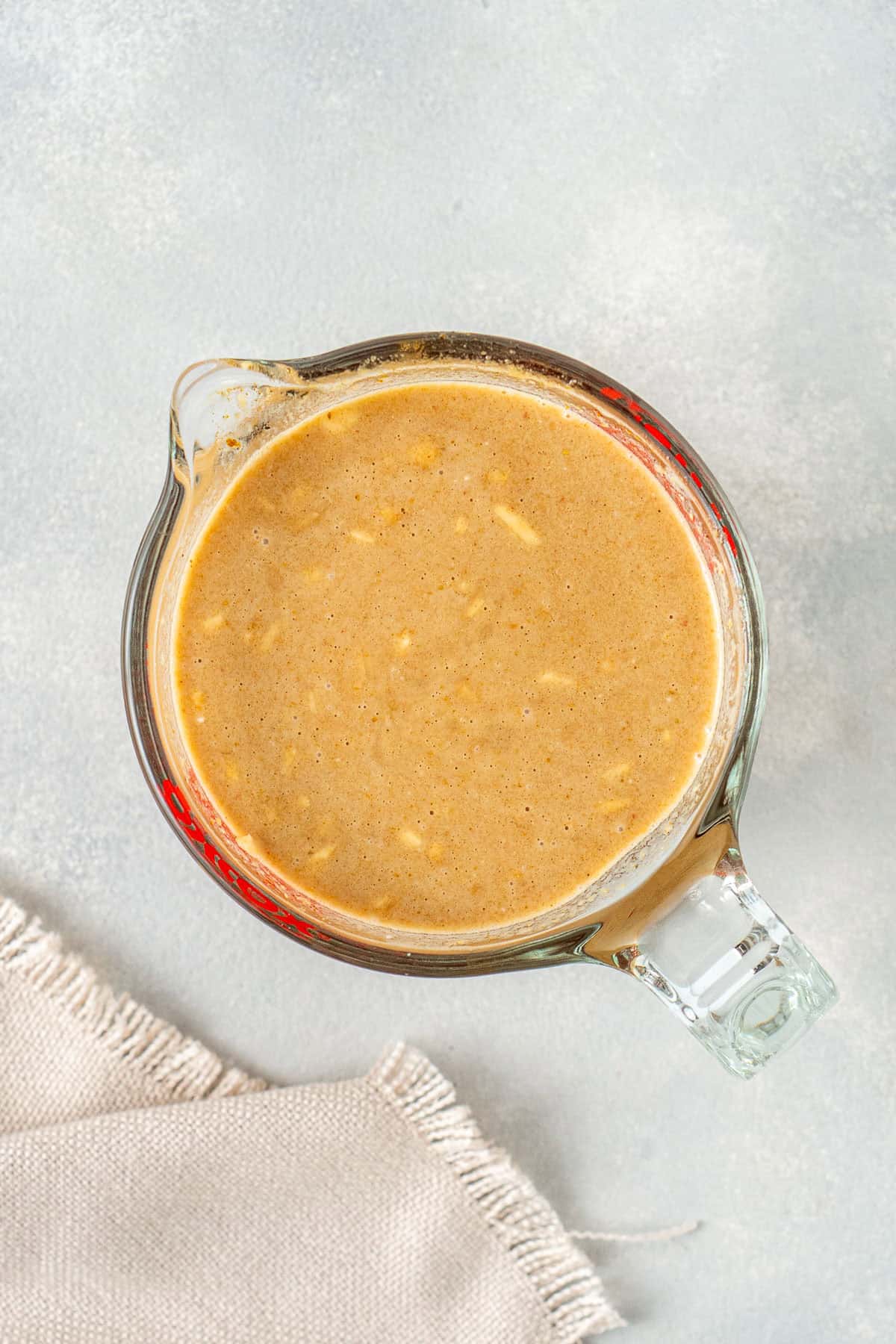 The satay sauce mixed together in a glass jug.