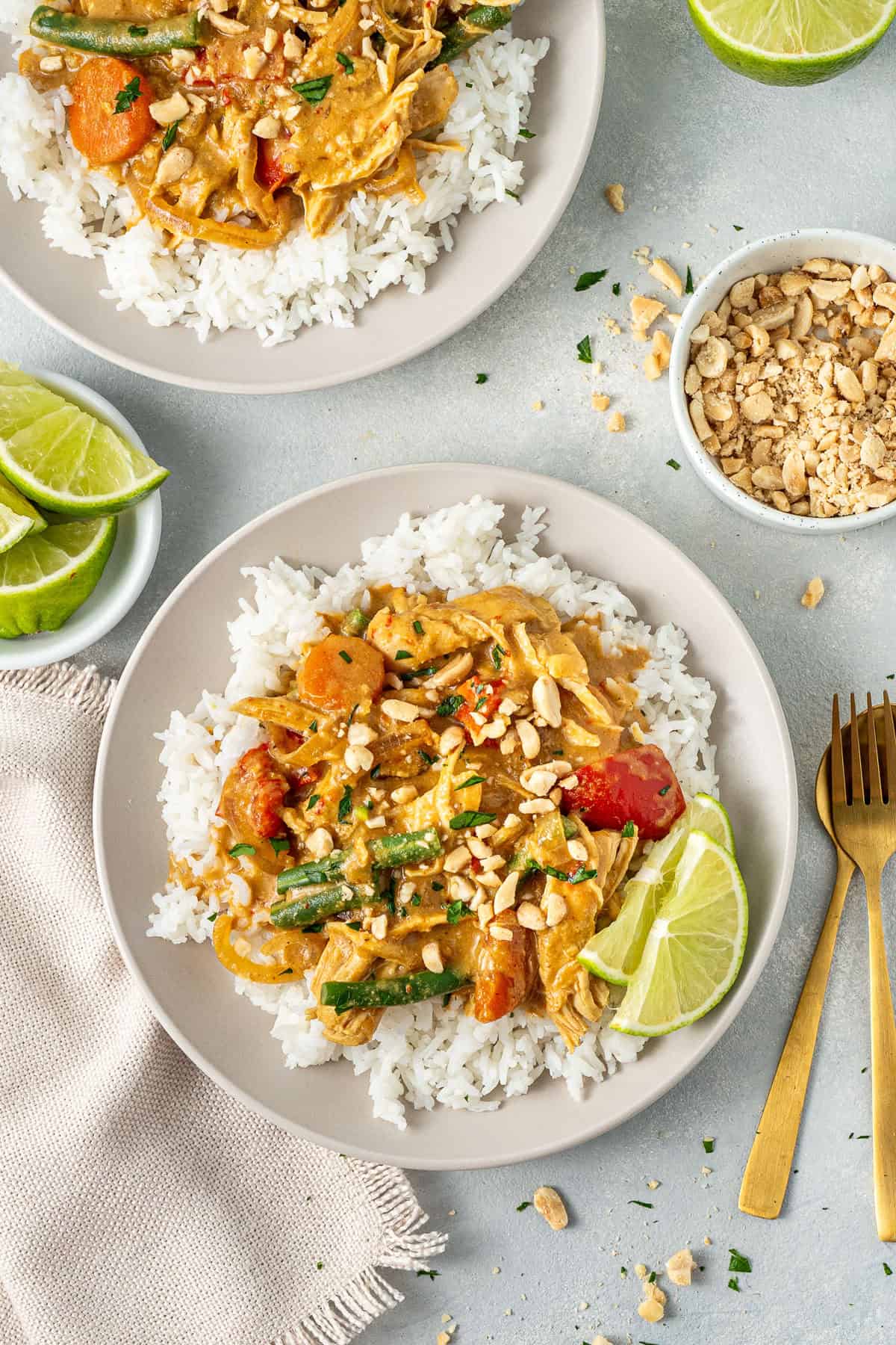 The served satay chicken over rice with fresh lime.