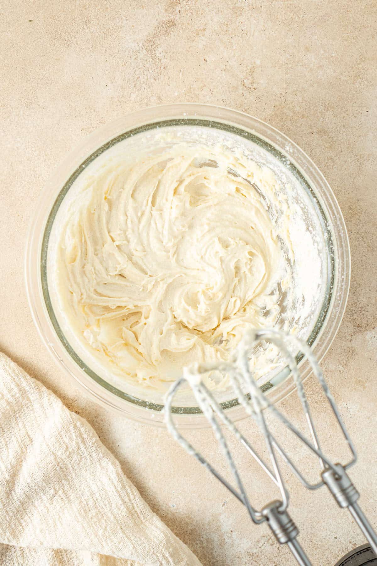 Mixing together the cake batter in a small bowl with electric beaters.