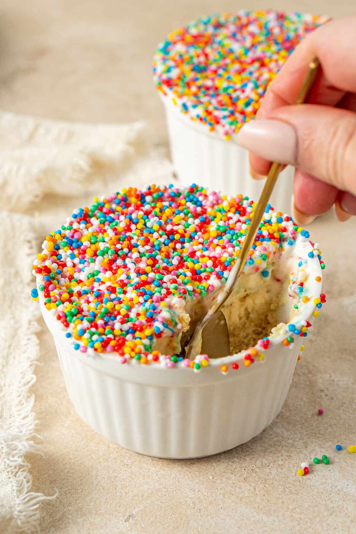 A spoon taking a bite of ice cream dot cakes.