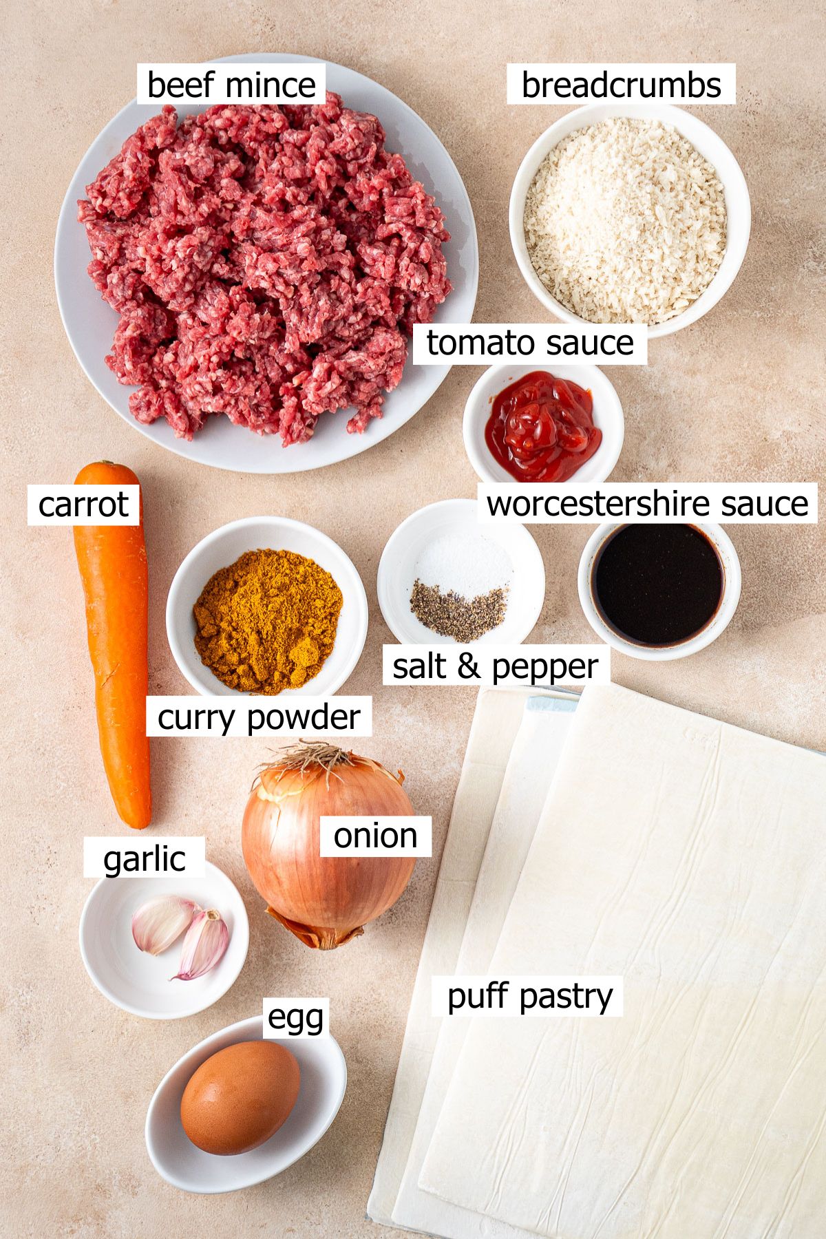 All ingredients needed to make curried sausage rolls laid out in bowls.