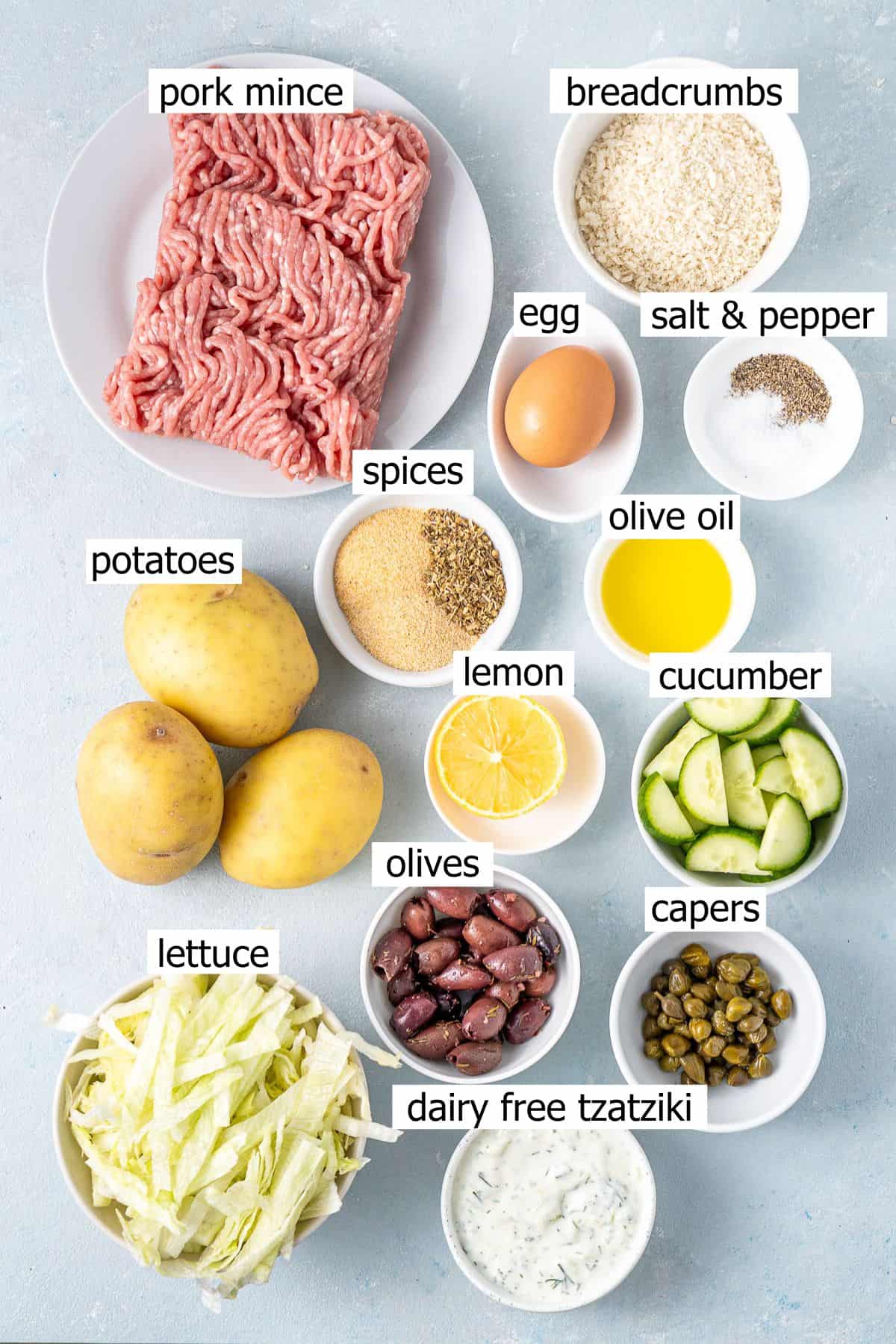 All ingredients needed to make greek meatball bowls laid out in small bowls.