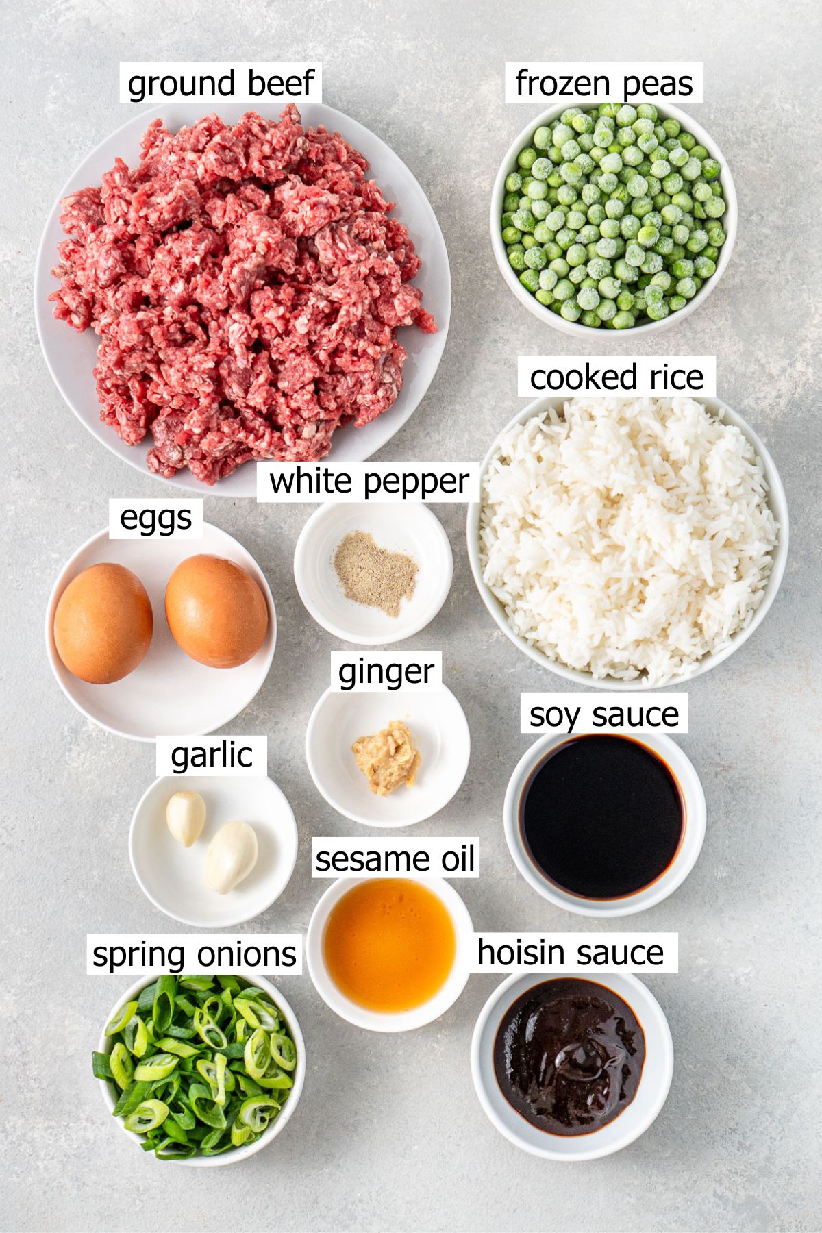 All ingredients needed to make ground beef fried rice laid out in small bowls.