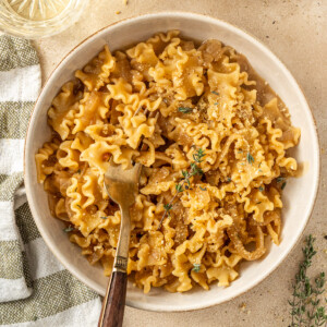 French onion pasta served into bowls with forks.