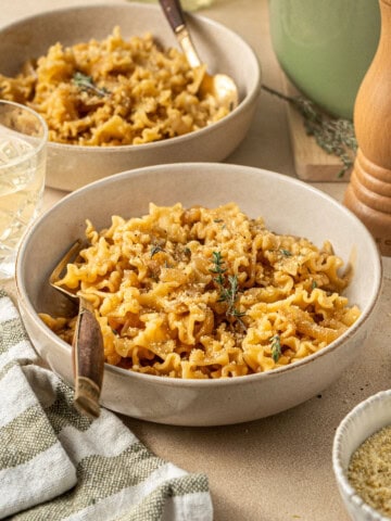 French onion pasta served into bowls with forks.