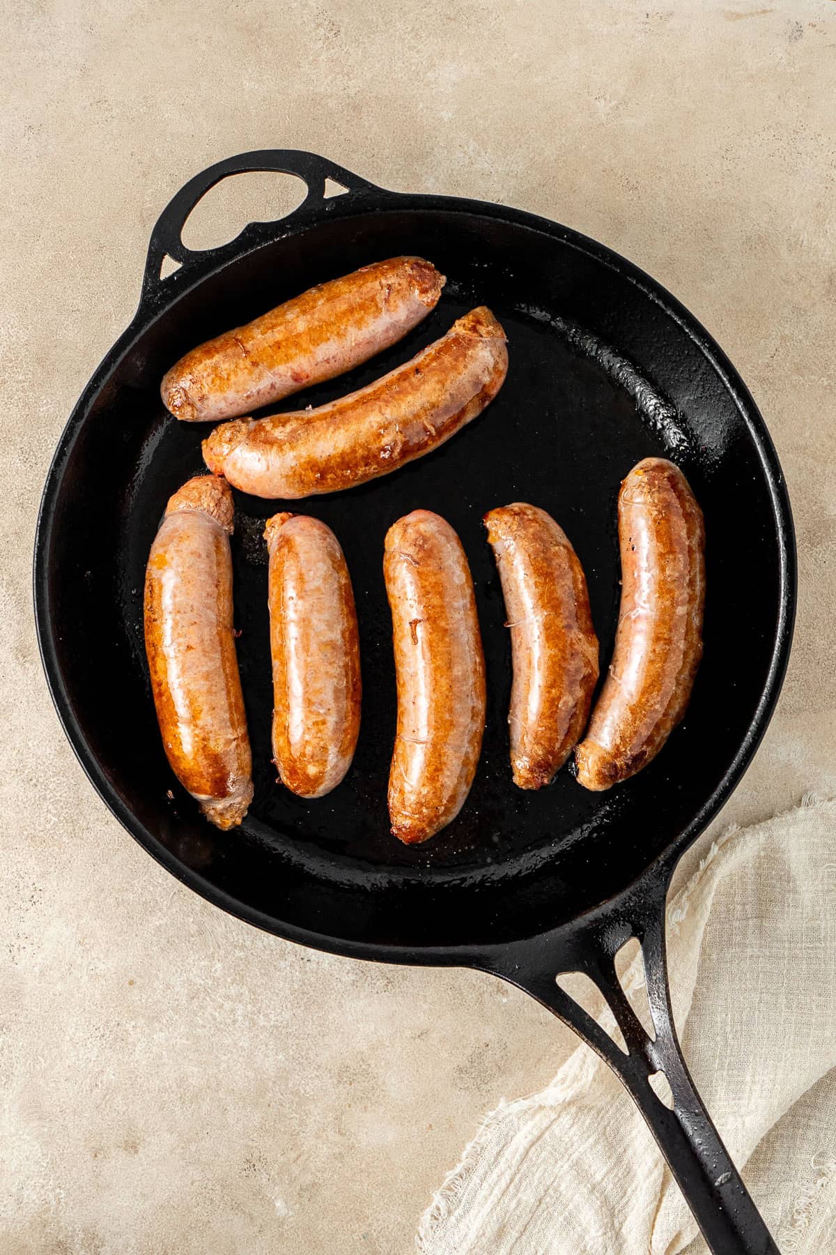 Browning the sausages in a cast iron pan.