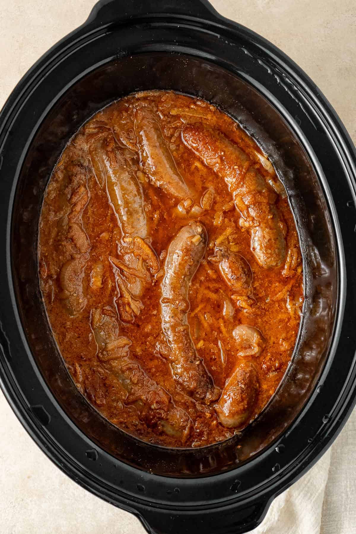 The cooked devilled sausages in the slow cooker.