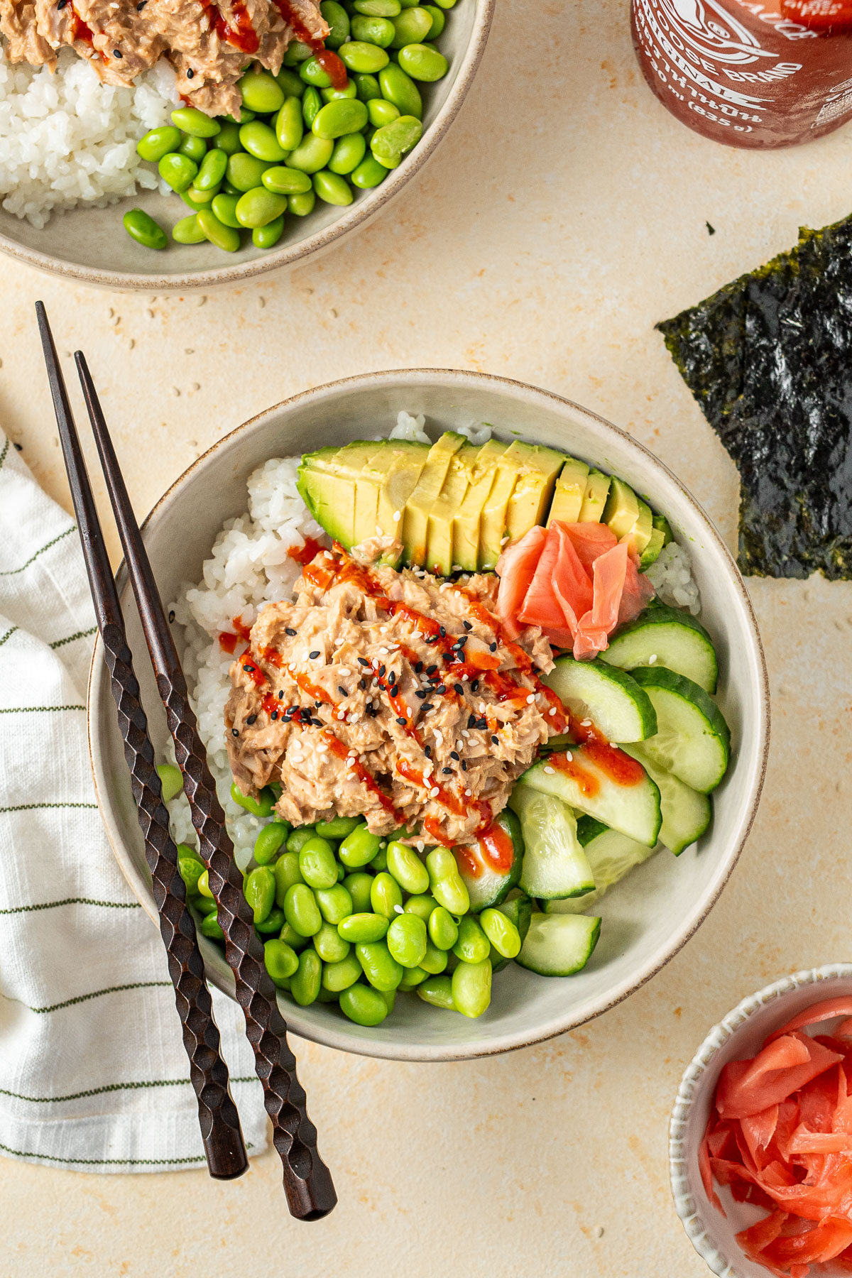 Tuna sushi bowls with avocado and edamame with chopsticks. 