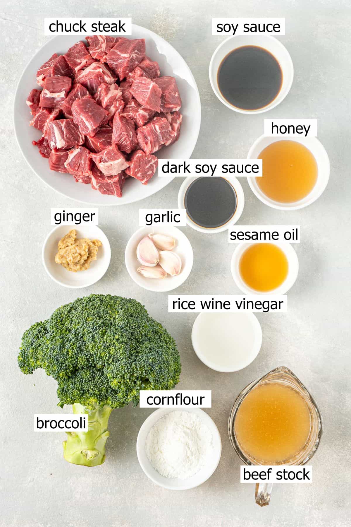 All ingredients needed to make beef and broccoli in the slow cooker laid out in small bowls.