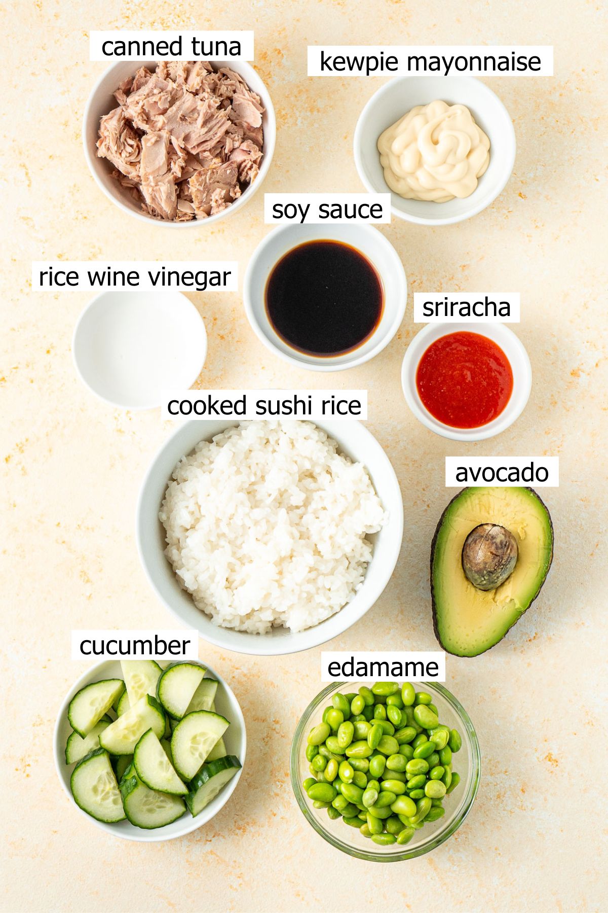 All ingredients needed to make spicy tuna sushi bowls laid out in small bowls.