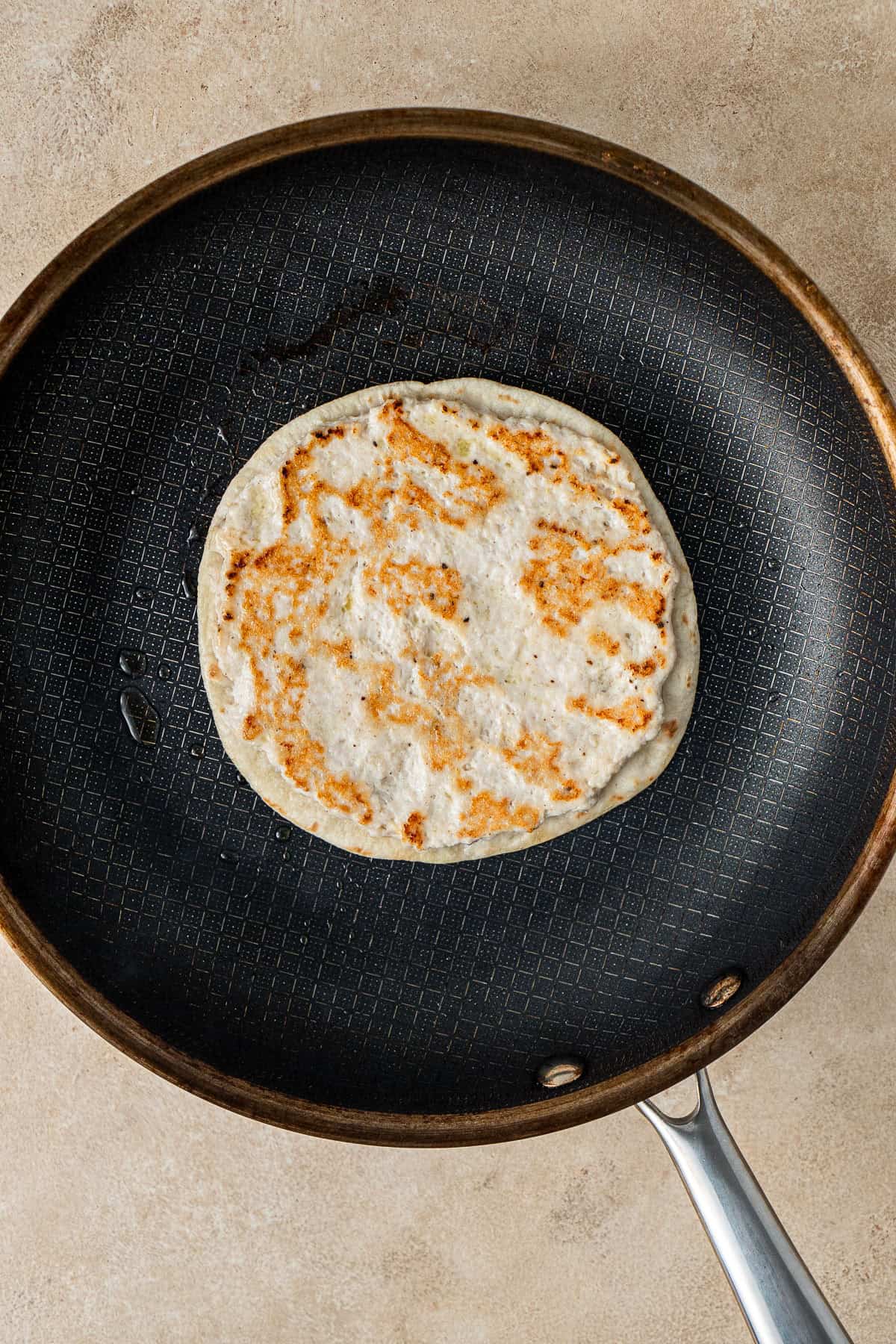 Cooking the chicken tacos in a frying pan.