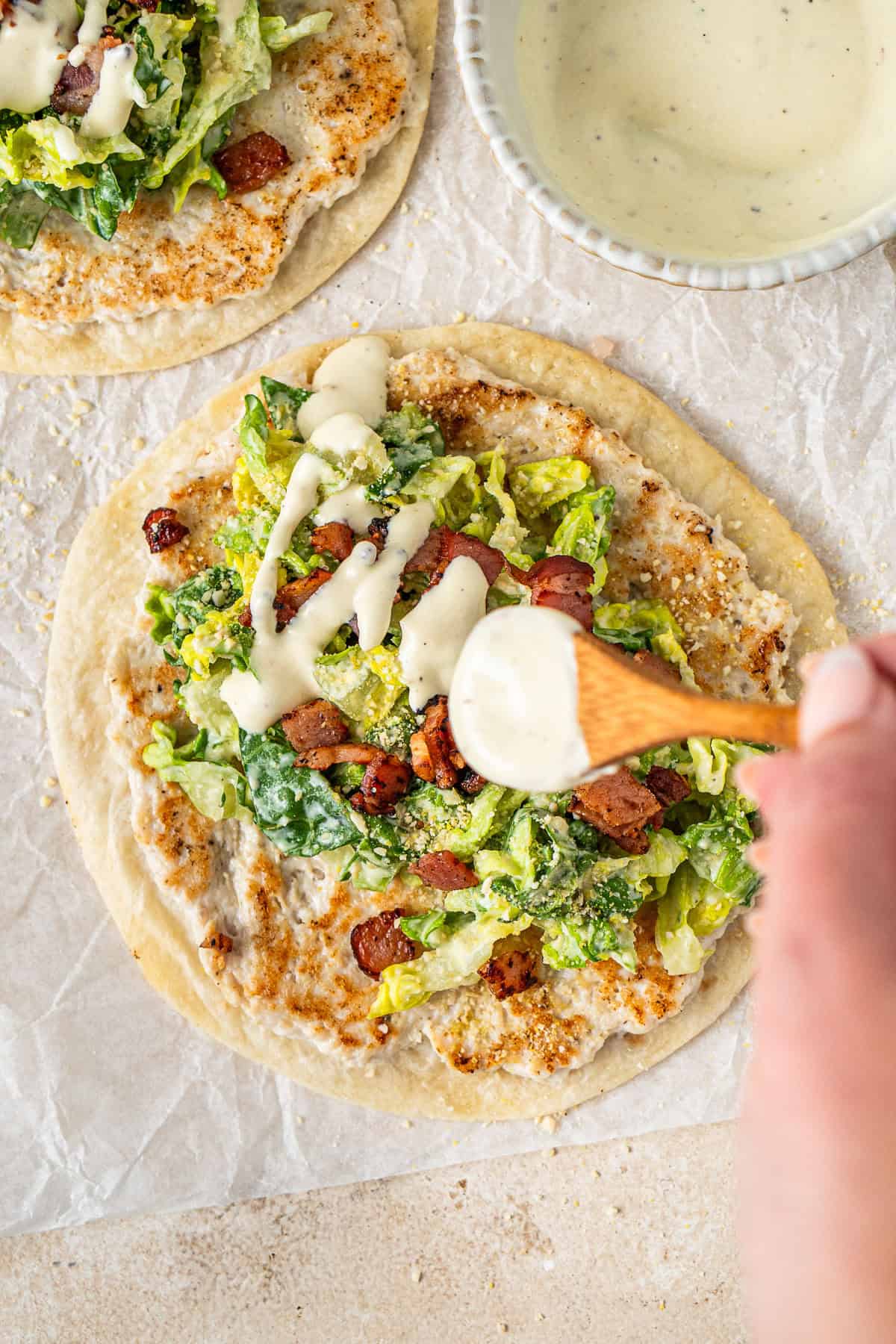Drizzling the extra dressing over the tacos.