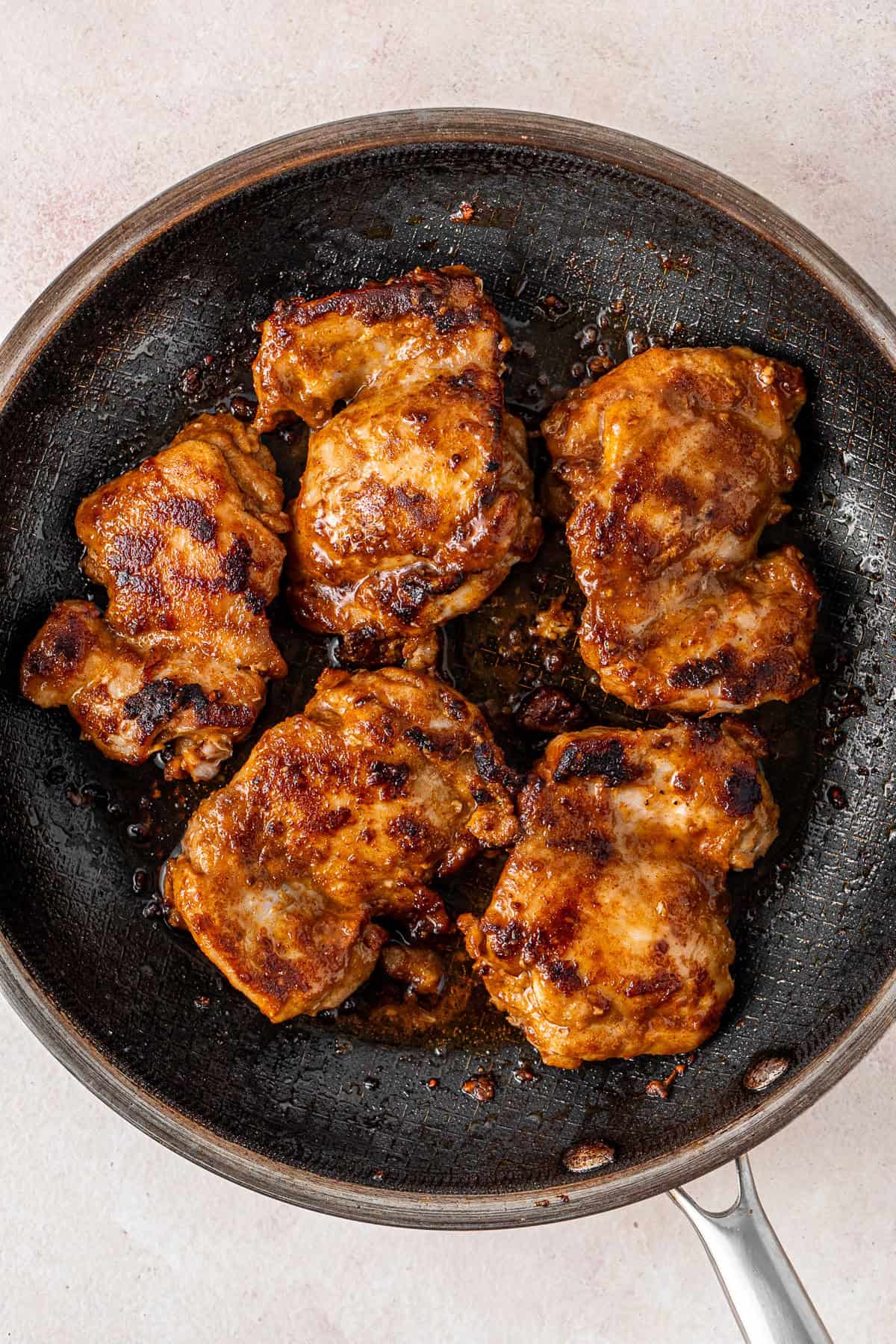 The cooked chicken in a frying pan.